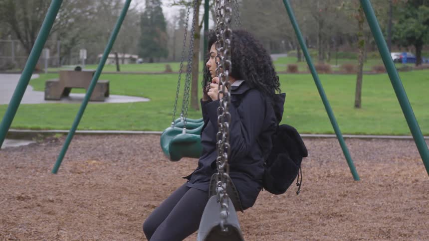 A girl swings on a park swing