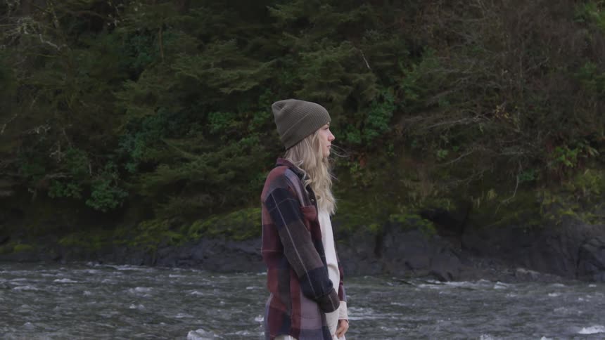 Woman stands on near a river