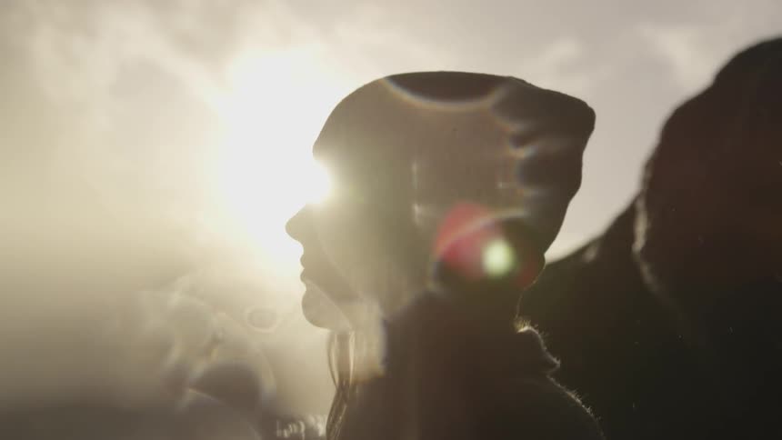 A young woman stands and looks at the landscape