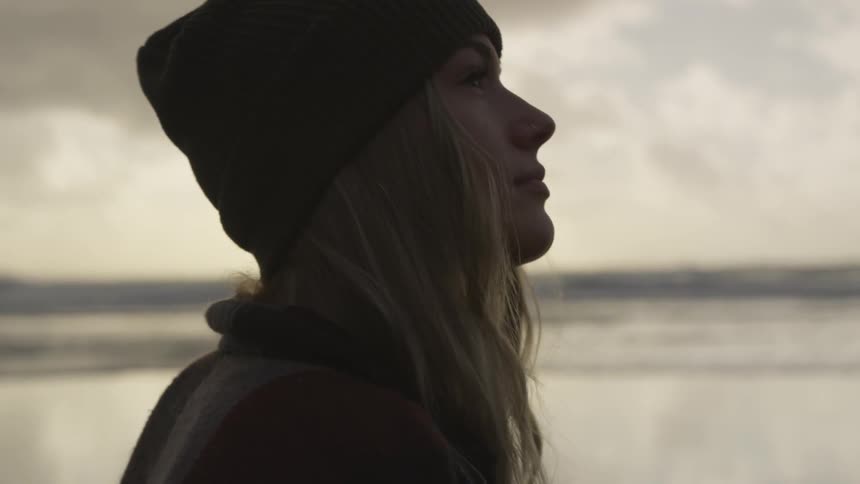 A woman staring into the sky near water