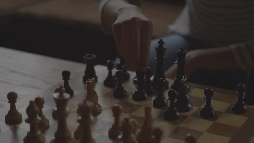 A person moves a chess piece