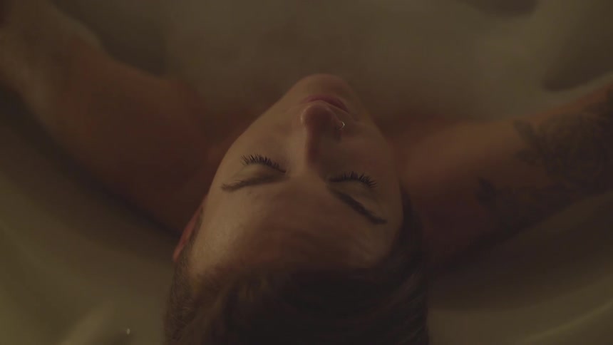 A woman takes a bubble bath