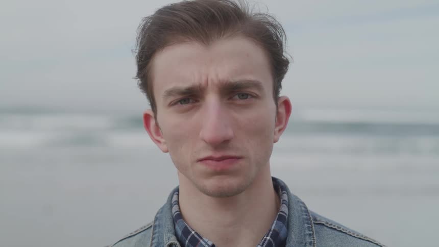 Man standing on a beach looking at the camera
