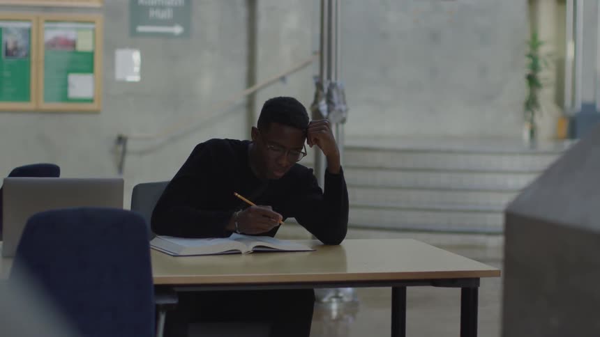 A man is studying while sitting at a desk