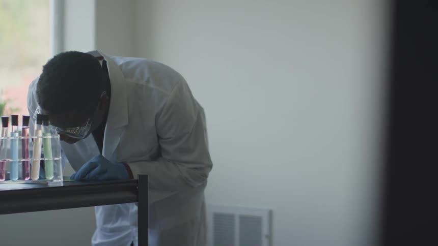 Chemist taking notes from an experiment of test tubes