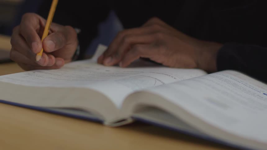 A person tracing around a book with a pencil