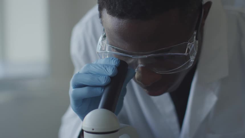 A man stares into a microscope