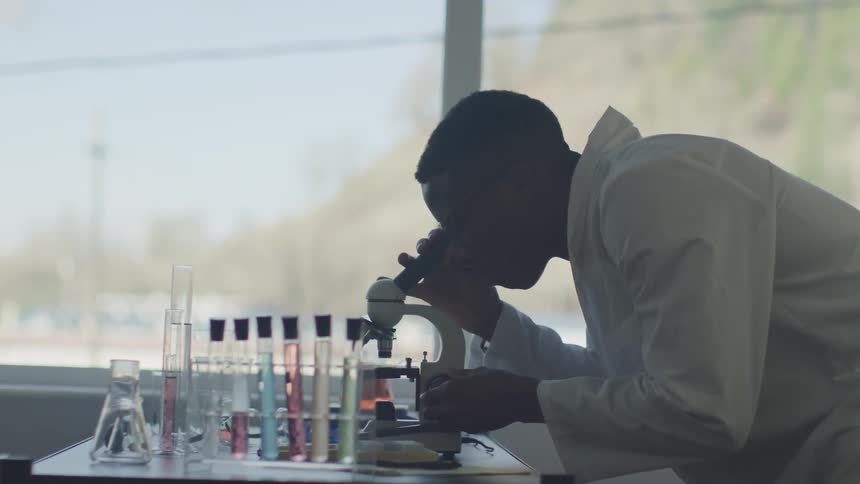A man looks into a microscope