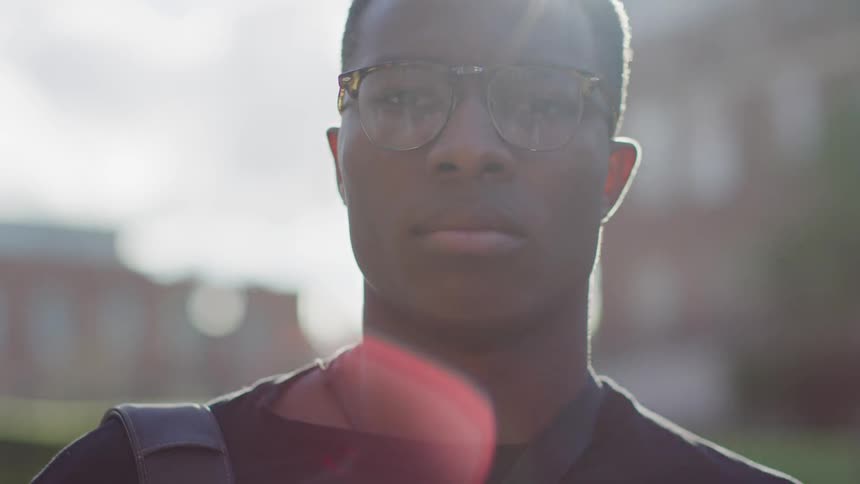 Man standing outside with the sun at his back while looking at the camera