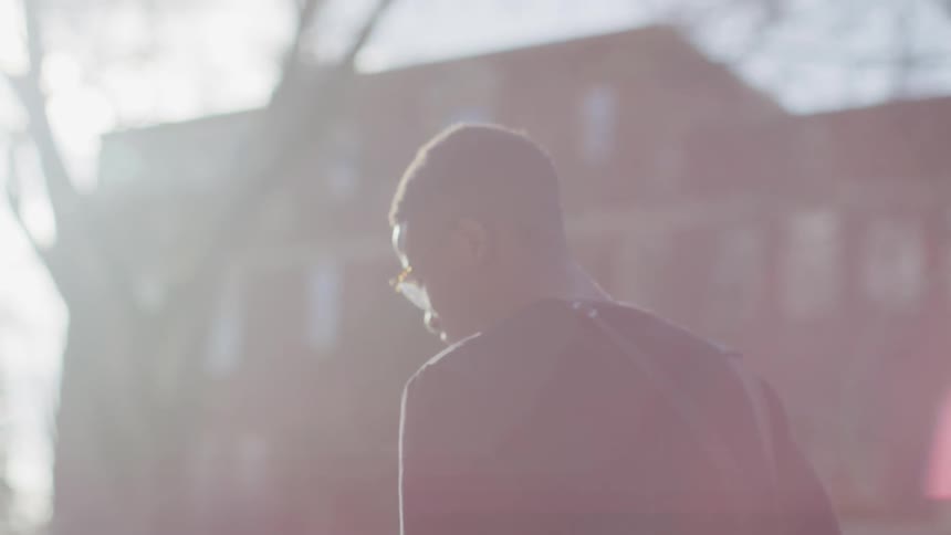 A young black man walks outside