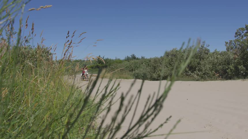 Man driving a motorcycle down a dirt road