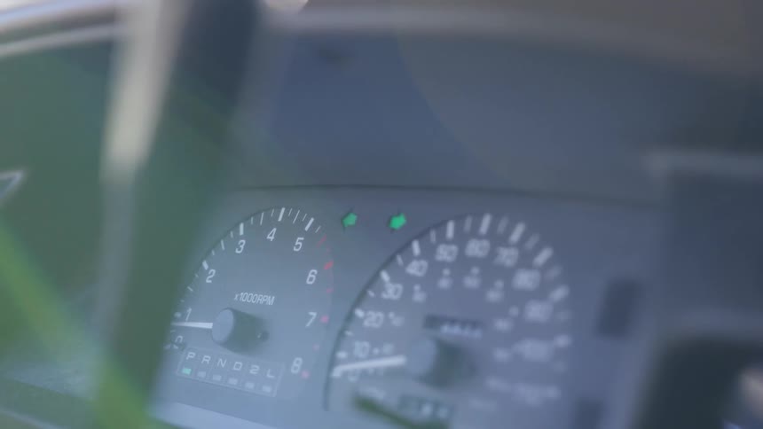Hazard lights blink on a car's dashboard