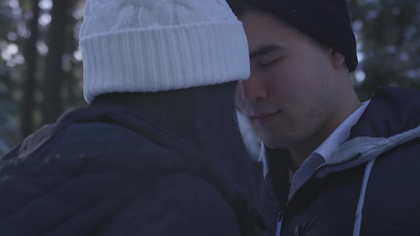 Two people sit with their heads together