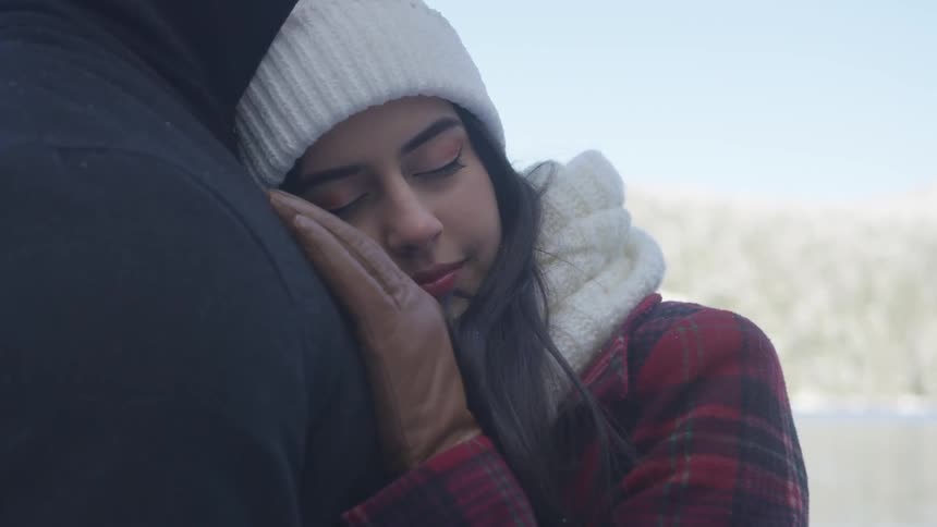 Woman cuddles against a man's chest