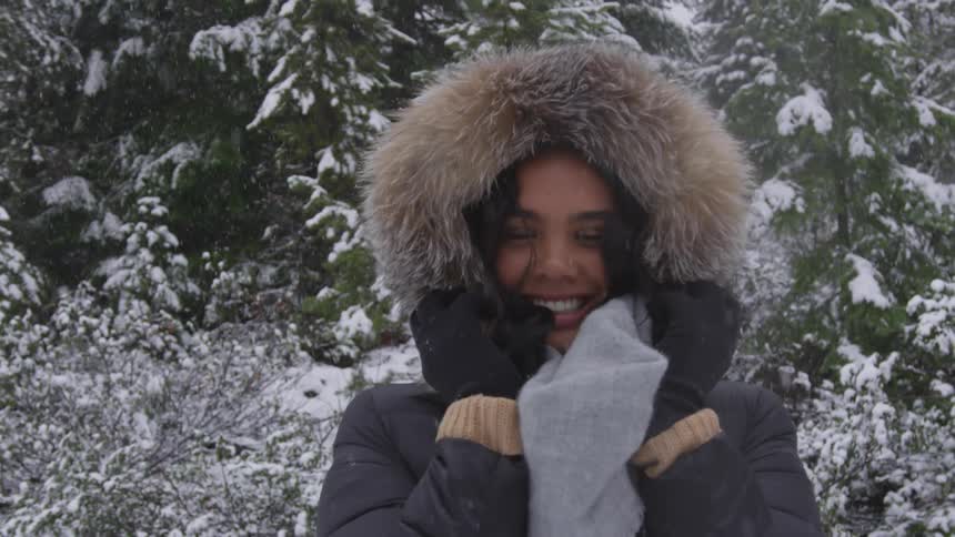 Young woman plays with the hood on her winter coat