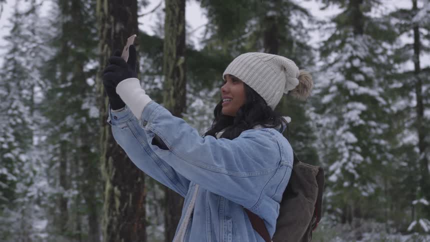 A woman takes a selfie near the trees