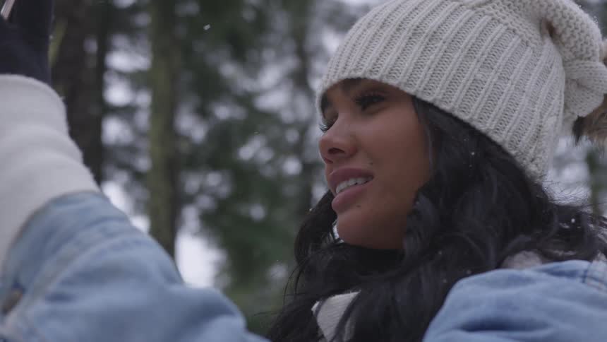 A black woman smiles for a selfie in the forest