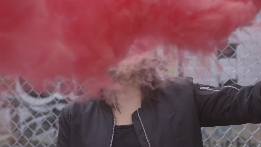 A young woman holds of a red flare
