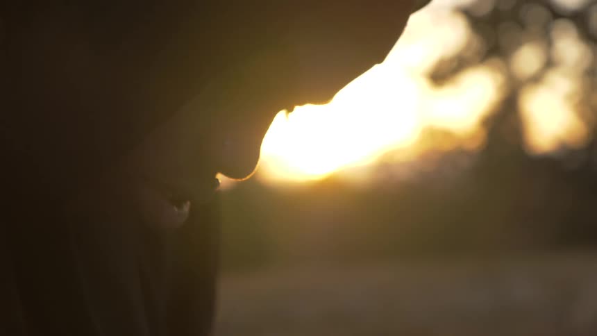 A man that is bent over looking down outdoors