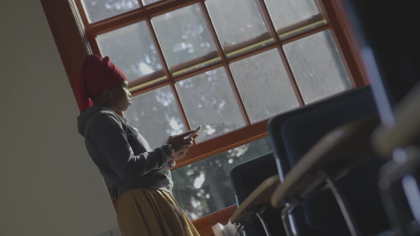 A woman is using her cell phone in the classroom