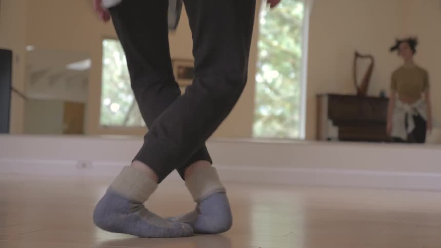 A woman is jumping in a dance studio