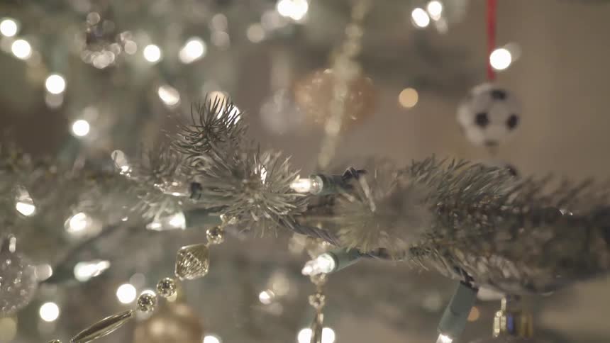 Twinkling lights and ornaments on a silver artificial christmas tree