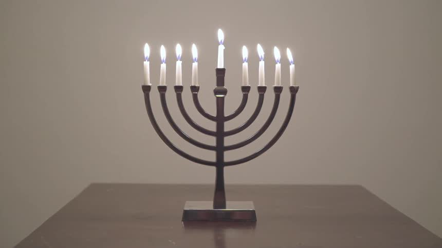 A lit menorah sitting on a table