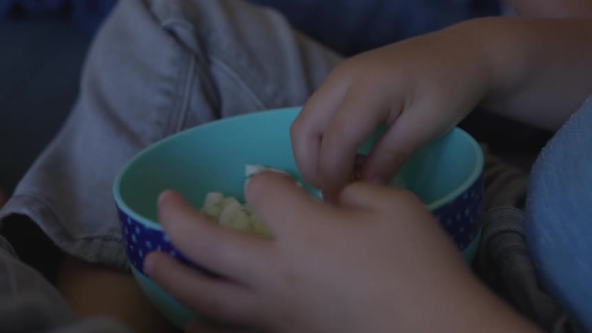 A child eating popcorn from a bowl