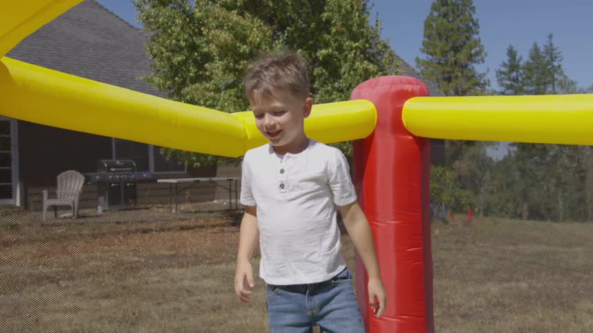 A little boy jumps in an inflatable bounce house