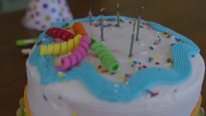 Five unlit candles are placed on a birthday cake