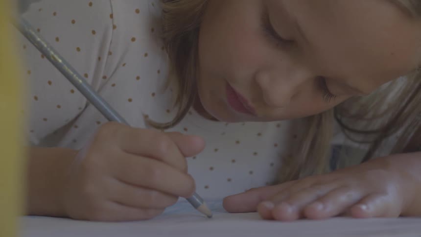 A girl is coloring with a pencil