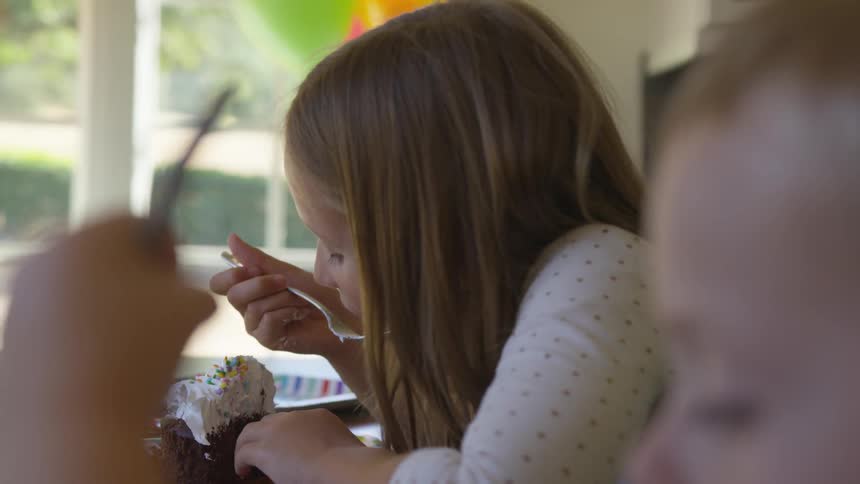 Young girl eats a cupcake with a fork