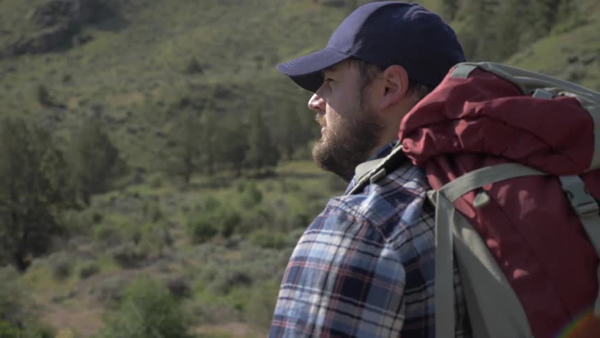 A man hikes in a hilly area