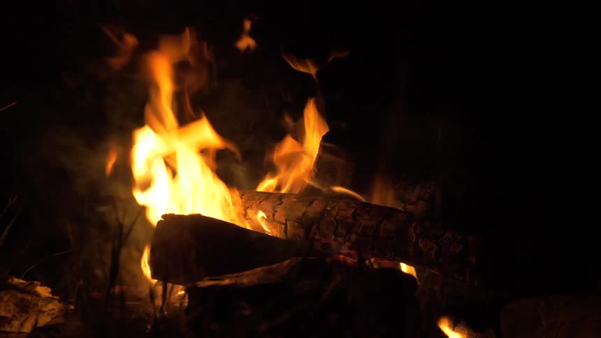 Fire consumes a pile of logs