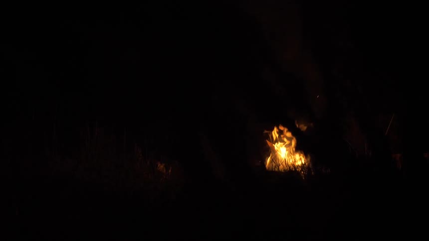 Bonfire lights up field at night