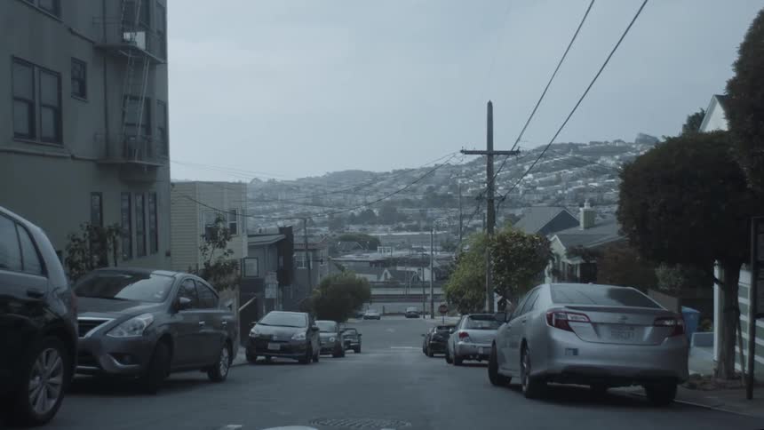 Cars are parallel parked near buildings