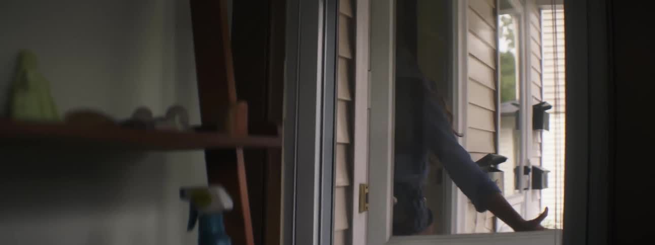Woman open door to a house holding a white cat