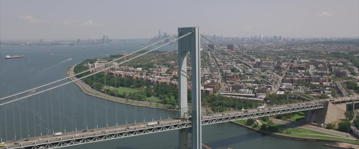 Cars traveling along a large bridge to a city