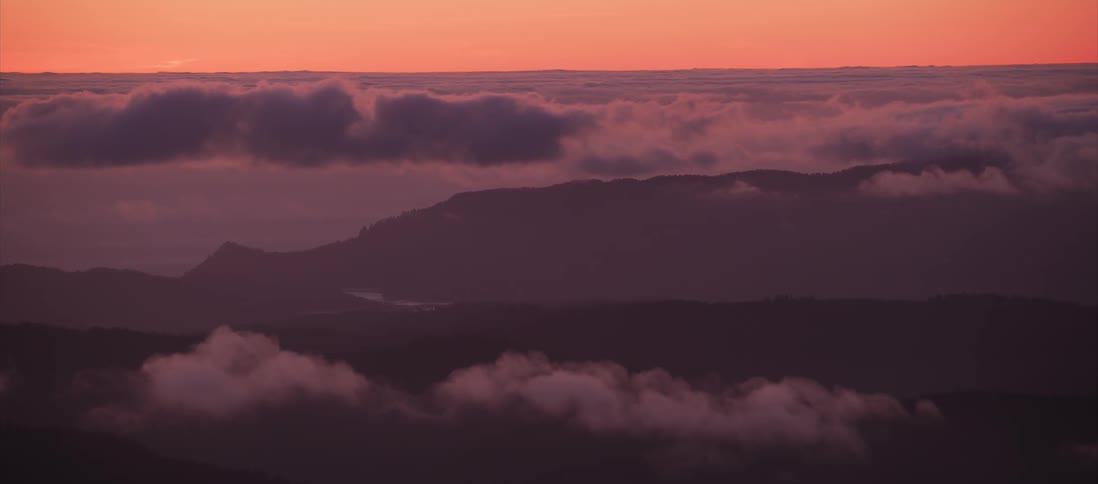 Orange sky over mountain and clouds