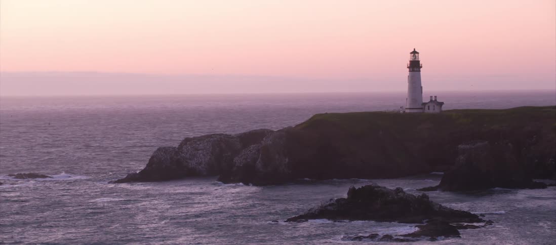 Lone beacon stands on a cliff overlooking the ocean