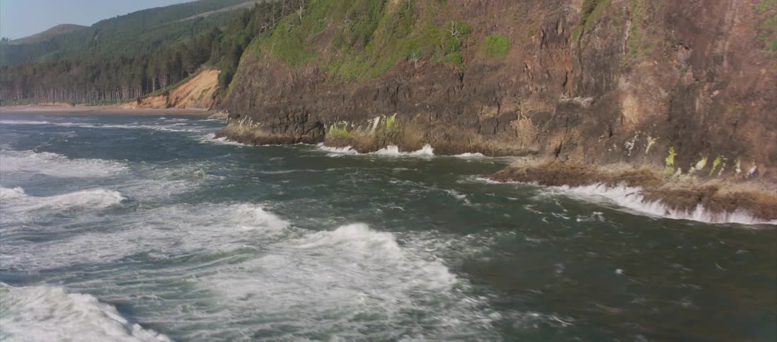Waves crash into a cliff