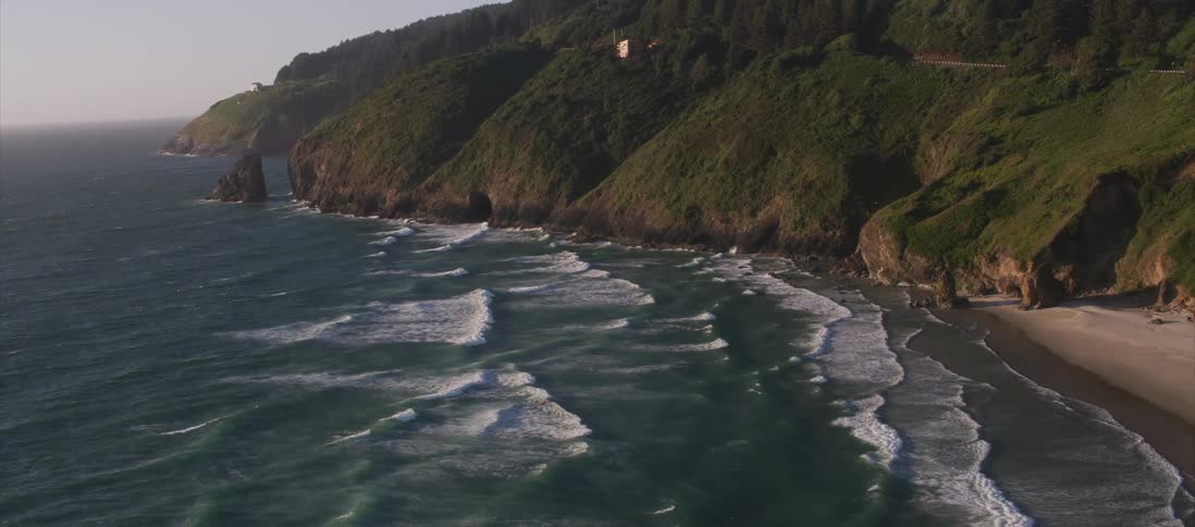 The camera flies over a coastal area
