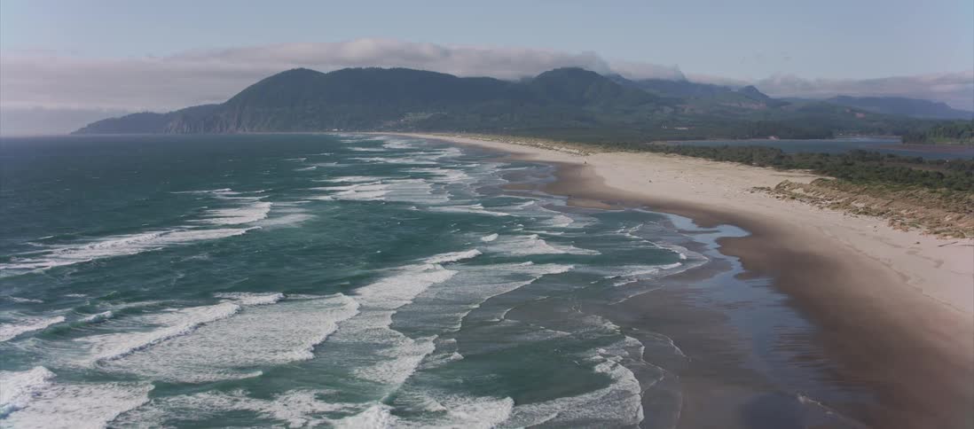 A long beach bordering a blue green sea