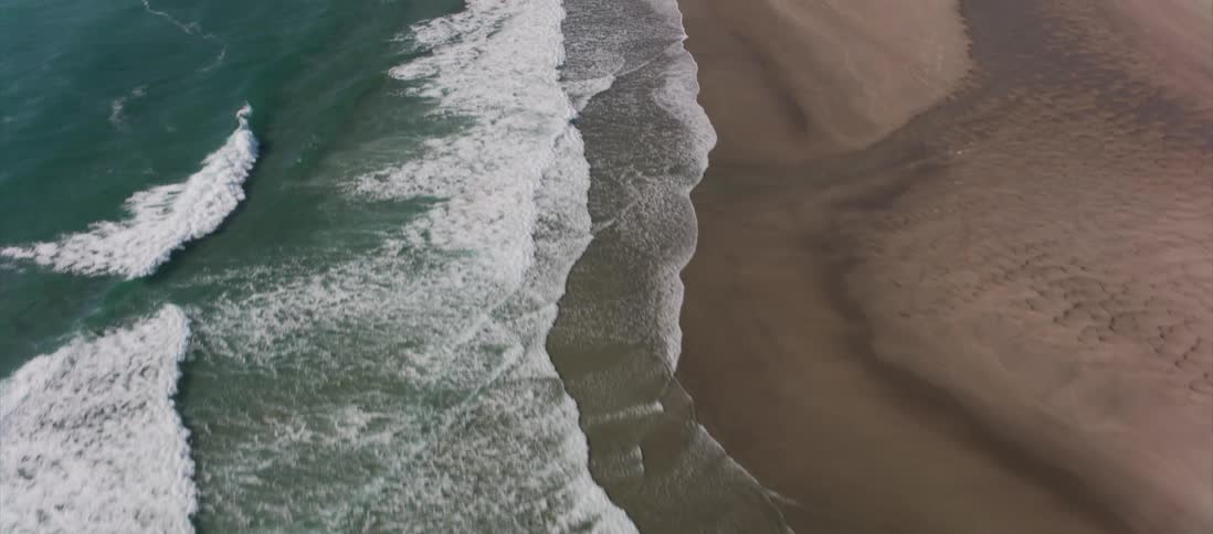 Green waves crash at an ocean coast