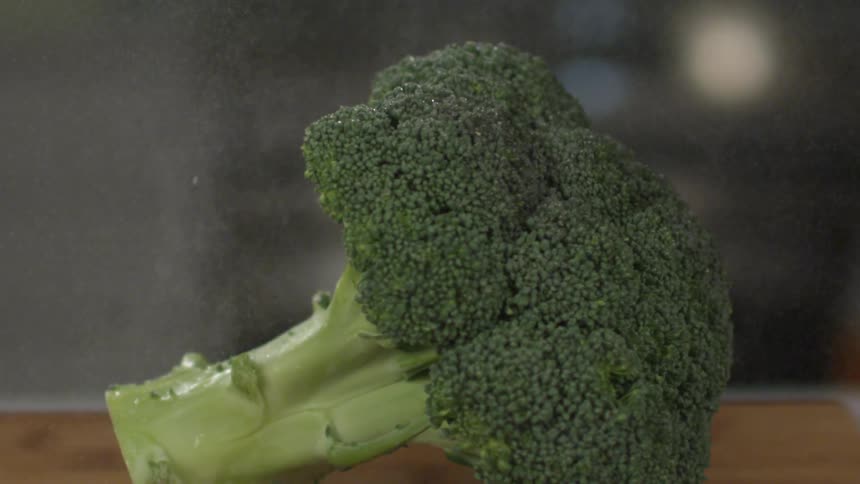 Mist pours down over a head of broccoli