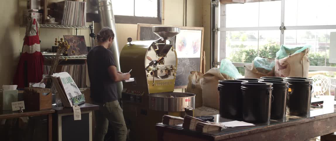 A man examines machinery and takes notes