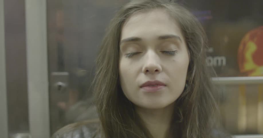 Long haired woman riding a subway