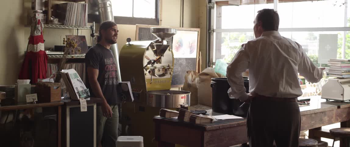Two men shake hands in a shop
