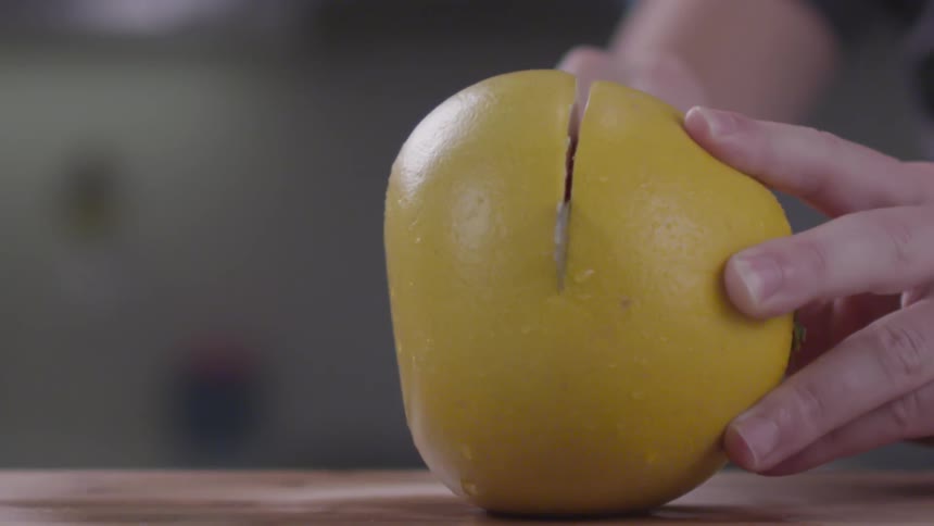 A person cutting a fruit