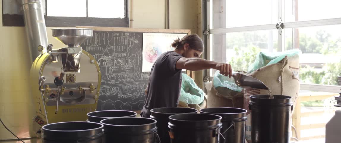 A person filling up black buckets